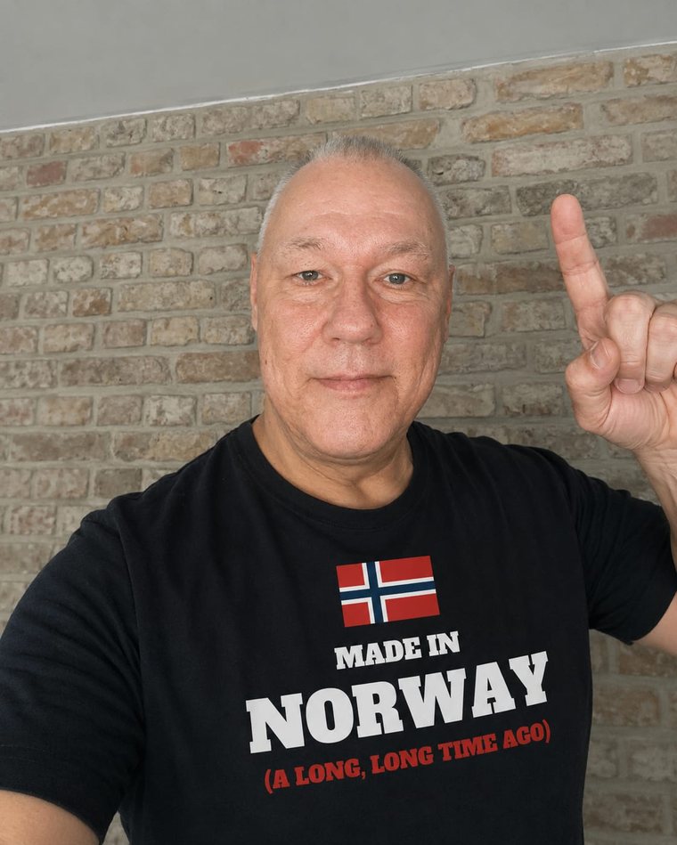 Per im T-Shirt „Made in Norway“ vor einer Backsteinwand